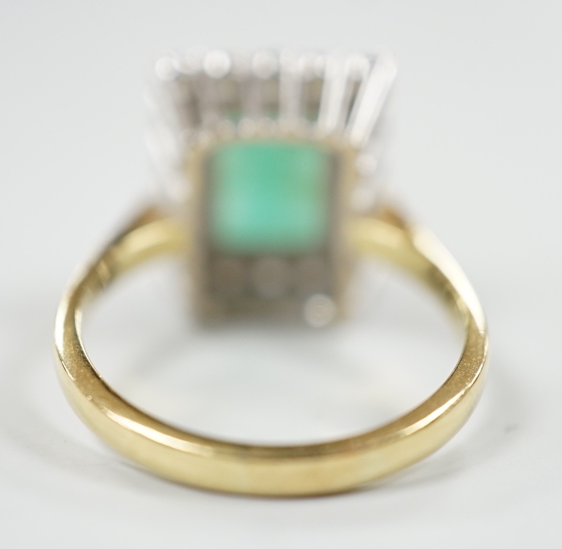 A modern 18ct gold, emerald and diamond set rectangular cluster ring, size Q, gross weight 6.4 grams.